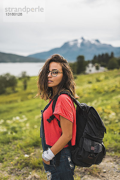 Junge Frau mit Rucksack im norwegischen Lappland unterwegs