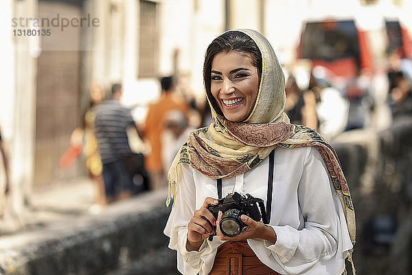 Spanien  Granada  junge arabische Touristin mit Hidschab  die während der Besichtigung der Stadt eine Kamera benutzt