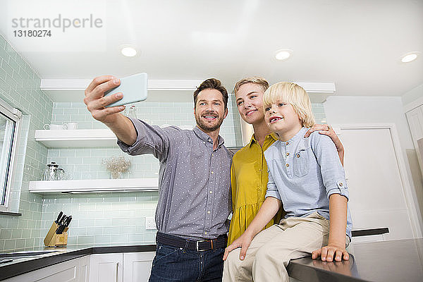 Vater nimmt Selfie mit seiner Familie in der Küche