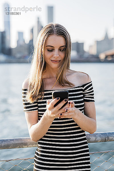 USA  New York  Brooklyn  junge Frau betrachtet Smartphone