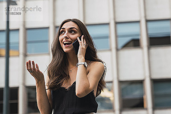 Porträt einer lächelnden jungen Frau am Telefon