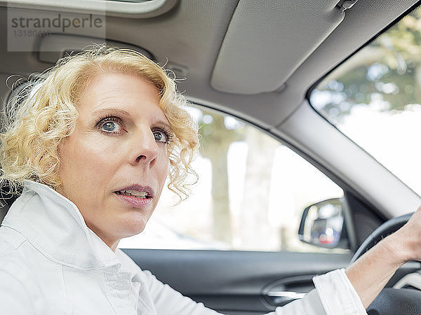 Porträt einer reifen Frau beim Autofahren