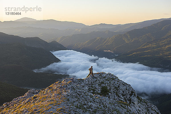 Italien  Umbrien  Sibillini-Nationalpark  Wanderer auf Aussichtspunkt bei Sonnenaufgang