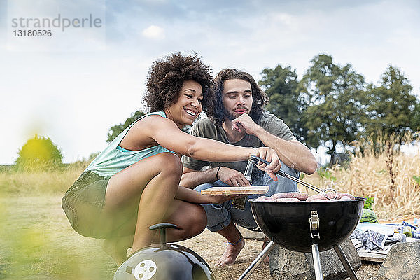 Glückliches Paar beim Grillen in der Natur