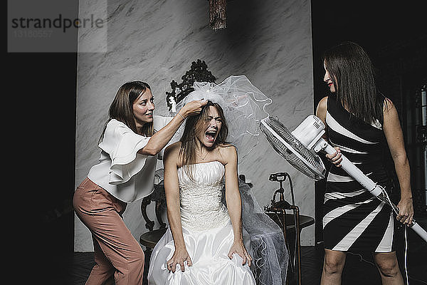 Verspielte Freunde und Braut bei der Hochzeitsvorbereitung