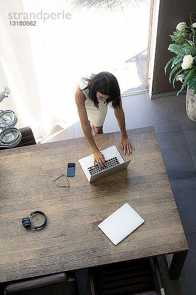 Draufsicht einer Frau mit Laptop am Schreibtisch