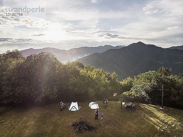 Italien  Toskana  Pistoia  Vater und Sohn auf einer Wiese neben Zelt und Motorrad