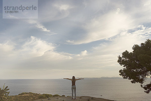 Spanien  Katalonien  Barcelona  Frau steht mit erhobenen Armen auf Aussichtspunkt  Naturpark Cap de Creus