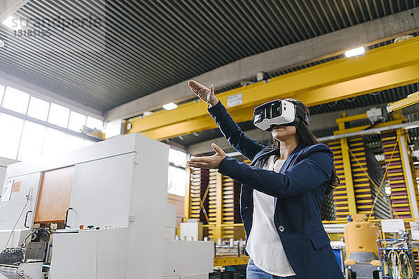 Junge Frau  die im Vertriebslager arbeitet und eine VR-Brille trägt