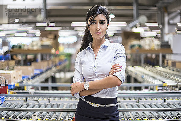 Porträt einer selbstbewussten Frau am Fließband in der Fabrik