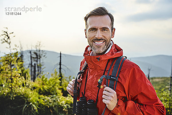 Porträt eines lächelnden Mannes beim Wandern in den Bergen