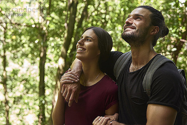 Spanien  Kanarische Inseln  La Palma  glückliches Paar steht in einem Wald und schaut auf