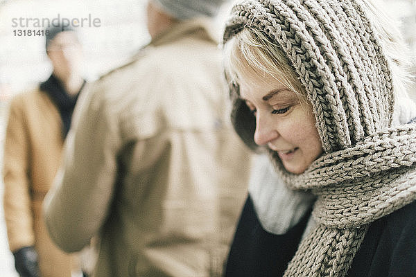 Lächelnde blonde Frau mit Strickschal