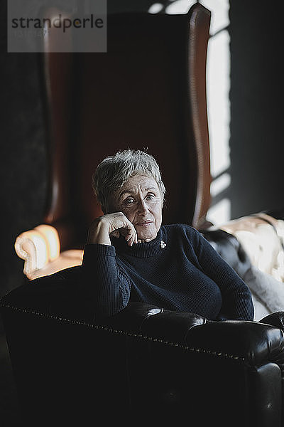 Porträt einer älteren Frau  die auf einer Couch sitzt