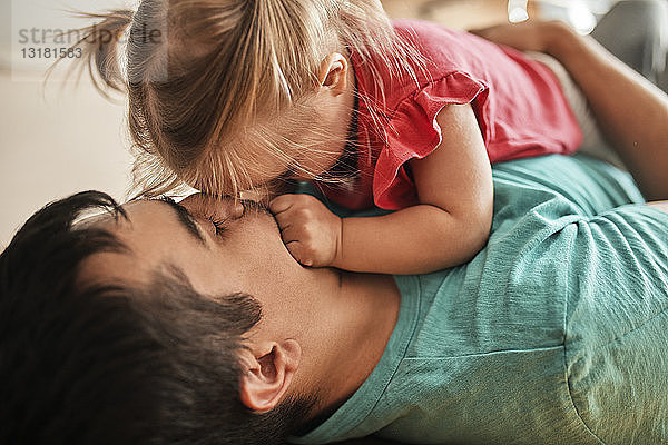 Vater und kleine Tochter kuscheln zu Hause zusammen