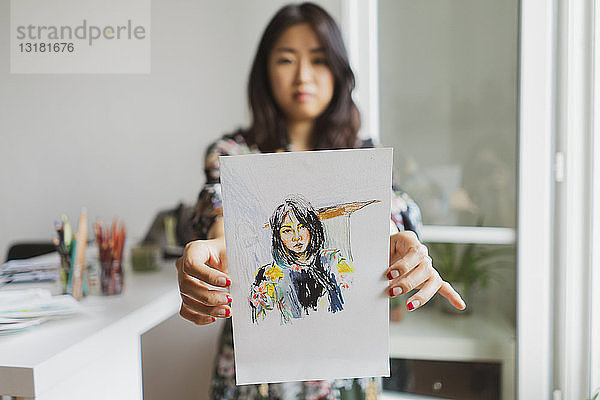 Illustrator zeigt Zeichnung mit Selbstporträt