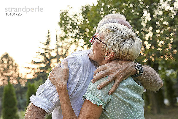 Glückliches älteres Paar umarmt sich im Freien