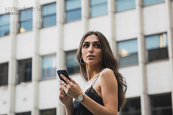 Porträt einer jungen Frau mit wartendem Handy