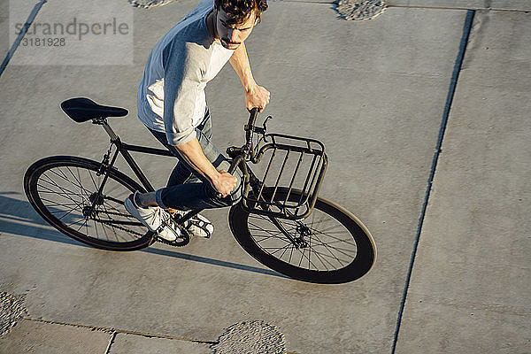 Junger Mann fährt Pendler-Fixie-Bike auf Betonplatten