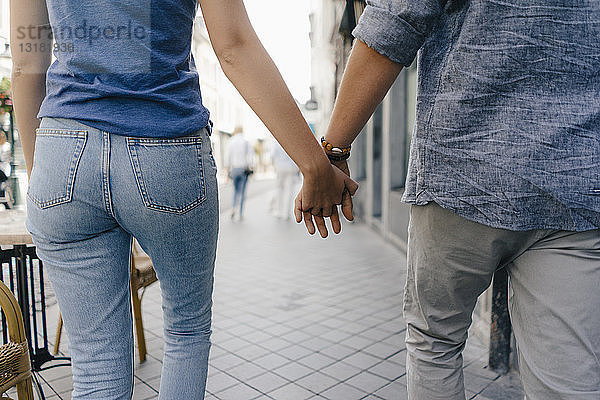 Niederlande  Maastricht  Nahaufnahme eines jungen Paares  das in der Stadt Hand in Hand geht