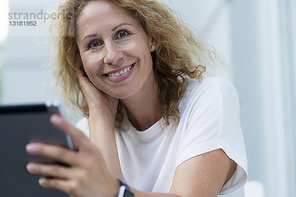 Porträt einer lächelnden Frau mit Tablette