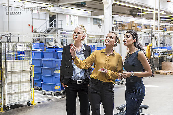 Drei Frauen im Gespräch in einer modernen Fabrik