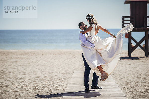 Glückliches Brautpaar genießt seinen Hochzeitstag am Strand
