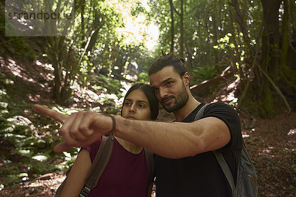 Spanien  Kanarische Inseln  La Palma  Ehepaar in einem Wald mit einem Mann  der mit dem Finger zeigt