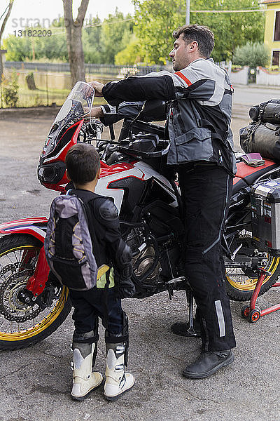 Vater und Sohn bereiten sich auf eine Motorradreise vor