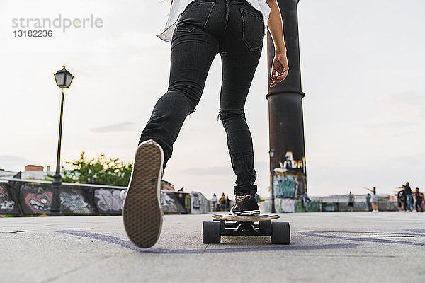 Nahaufnahme einer jungen Frau beim Skateboardfahren in der Stadt