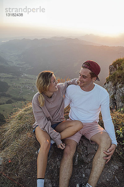 Schweiz  Grosse Mythen  glückliches junges Paar auf einer Wanderung mit Pause bei Sonnenaufgang
