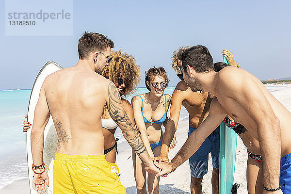 Gruppe von Freunden am Strand beim Händestapeln
