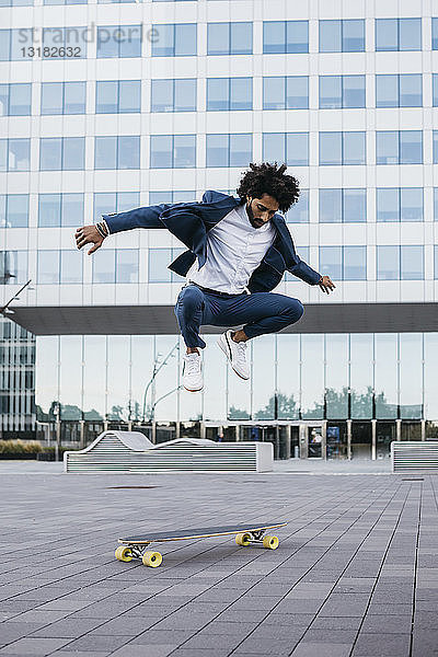 Spanien  Barcelona  junger Geschäftsmann macht Skateboardtricks in der Stadt