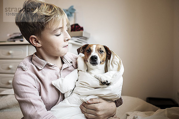 Junge mit Jack Russel Terrier in eine Decke gewickelt