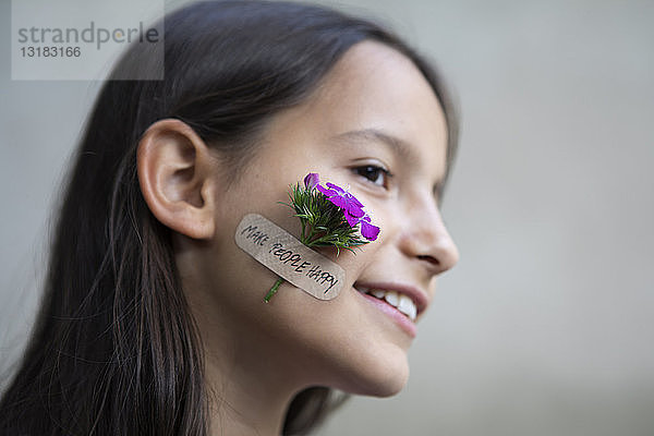 Bildnis eines lächelnden Mädchens mit Blumenkopf auf der Wange