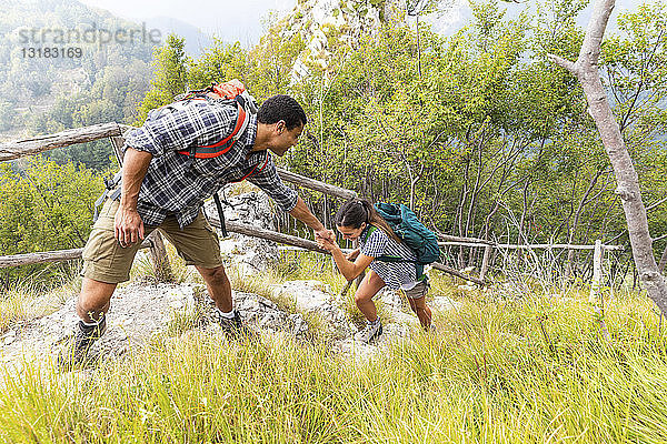 Italien  Massa  Mann hilft einer jungen Frau beim Treppensteigen in den Alpi Apuane