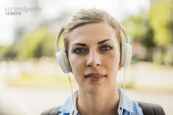 Porträt einer selbstbewussten Frau mit Kopfhörern