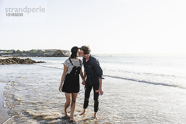 Frankreich  Bretagne  junges Paar küsst sich am Strand