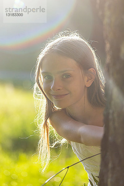 Porträt eines lächelnden Mädchens in der Natur im Gegenlicht