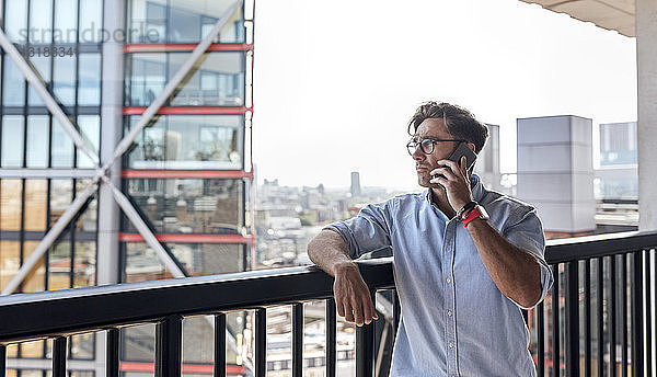 UK  London  Mann am Telefon auf einer Dachterrasse