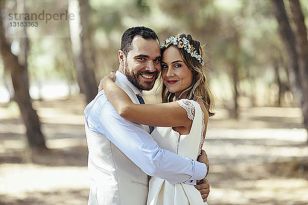 Porträt eines glücklichen Brautpaares Kopf an Kopf stehend im Kiefernwald