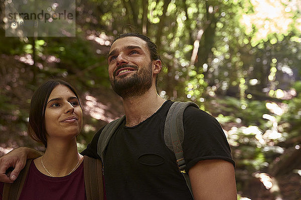 Spanien  Kanarische Inseln  La Palma  lächelndes Paar in einem Wald  das sich umsieht