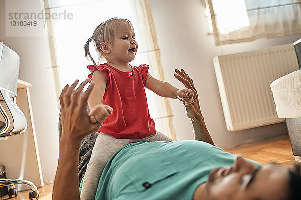 Kleines Mädchen spielt zu Hause mit ihrem Vater