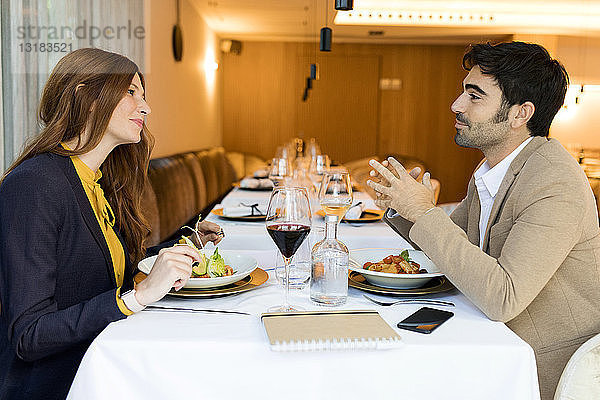 Lächelnder Mann und lächelnde Frau beim Essen in einem Restaurant