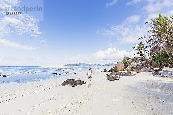 Seychellen  La Digue  Anse Source d'Argent  Frau beim Strandspaziergang