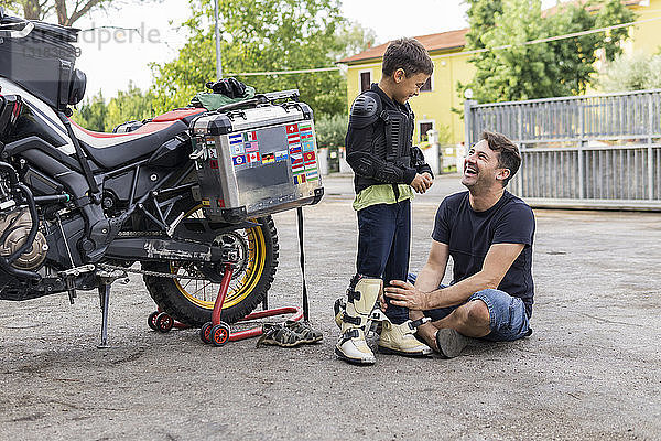 Glücklicher Vater und Sohn neben einem Motorrad