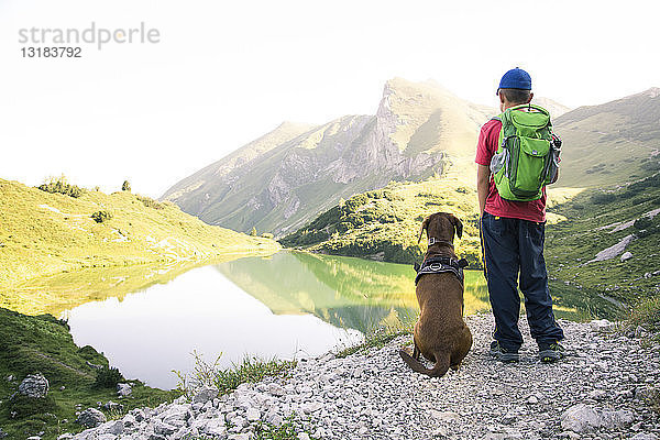 Österreich  Südtirol  Junge steht neben seinem Hund