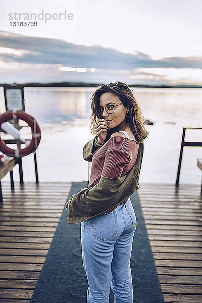 Hübsche junge Frau posiert auf einem Pier am Inari-See  Finnland
