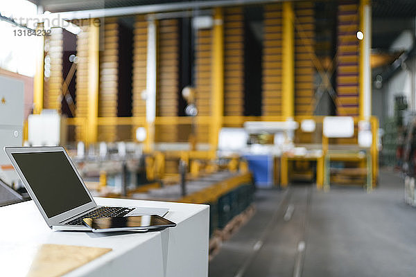 Laptop und digitales Tablett im Logistikzentrum