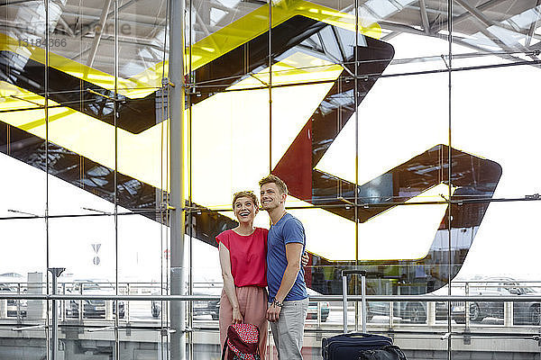 Glückliches Paar steht auf dem Flughafen